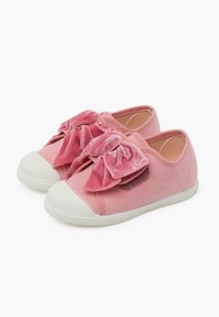 Scarpe in velluto rosa con grandi fiocchi sulla parte anteriore, suole in gomma bianca con un motivo testurizzato e un design a punta arrotondata.