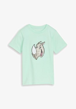 T-shirt vert clair à manches courtes avec une tête de rhinocéros dessin animé souriante en sequins argentés et blancs sur le devant.