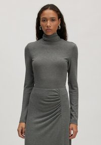 Grijze coltrui jurk met lange mouwen, met een aangesloten bovenlichaam en gathered detail in de taille, gemaakt van zachte jersey stof.