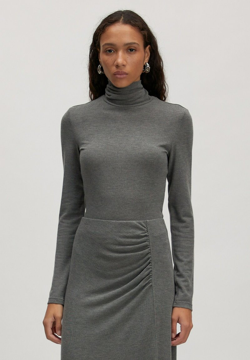 Grijze coltrui jurk met lange mouwen, met een aangesloten bovenlichaam en gathered detail in de taille, gemaakt van zachte jersey stof.