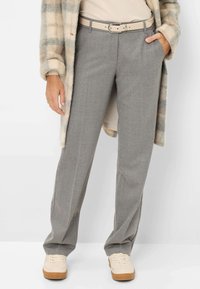 Grijze op maat gemaakte broek met een subtiele textuur, een hoge taille en een beige riem. Gecombineerd met lichtgekleurde casual schoenen.