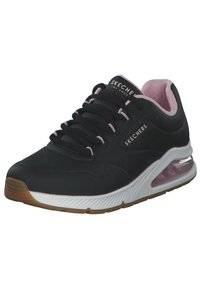 Zapatilla deportiva negra con acentos rosas, que cuenta con una parte superior suave, diseño de cordones, interior acolchado y una suela de amortiguación de aire transparente.