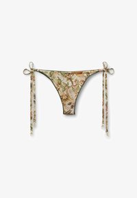 Parte inferior de bikini con estampado floral de hojas verdes, beige y marrones, con lazos laterales que terminan en pequeños colgantes dorados.
