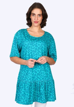 Tannengrünes Tunika-Kleid mit floralem Muster, rundem Ausschnitt, kurzen Ärmeln und Rüschensaum. Hergestellt aus leichtem, weichem Stoff.