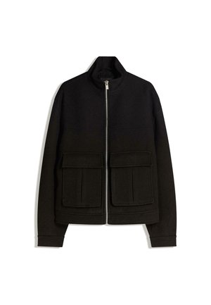 Sort lynlåstrøje med ståkrave, to store frontlommer med klap og lange ærmer, vist på en hvid baggrund.