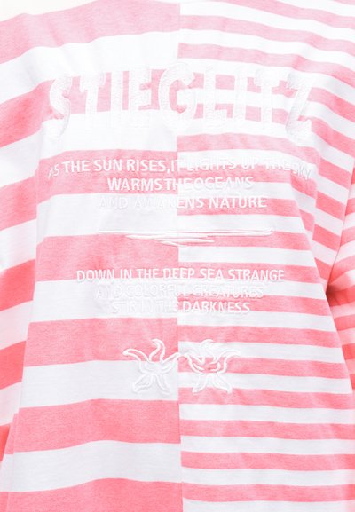 Ροζ και λευκό ριγέ ύφασμα με κεντημένο κείμενο για τον ήλιο, τη θάλασσα και τη φύση, με δύο απεικονίσεις αστεριών της θάλασσας.