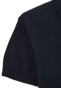 Camisa polo de manga corta azul marino con un tejido texturizado, que presenta puños y cuello de canalé. Tela suave y uniforme sin patrones.