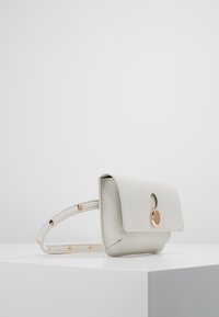 Biały skórzany torebka o teksturowanej powierzchni z klapką i złotymi elementami. Posiada cienki pasek z dekoracyjnymi ćwiekami po jednej stronie.