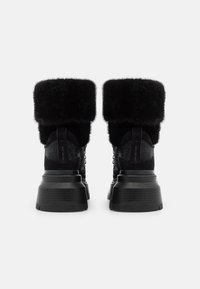 Zwarte enkelboots met een textiel bovenwerk en een fluffy bontmanchet. Voorzien van een dikke zwarte zool en een vetersluiting voor een veilige pasvorm.