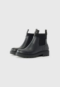 Black waterproof ankle boots with a smooth rubber body, elastic side panels, and a chunky, textured sole. Featuring contrasting branded pull tabs.