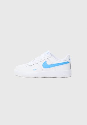 Baskets blanches de sport avec une finition en cuir lisse, présentant des accents bleu clair sur le logo Swoosh et les œillets, ainsi qu'une semelle en caoutchouc texturée.
