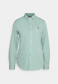 Zeleno-bílý pruhovaný dlouhý rukáv, který má límec na knoflíky, přední knoflíky a malé vyšívané logo na hrudi.