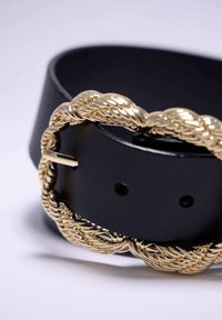 Ceinture en cuir noir avec une boucle tressée en or, présentant une texture lisse et plusieurs trous d'ajustement pour le taille.
