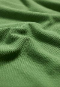 Texturált zöld szövet, finom szőtt mintával, lágy redőkkel és sima felülettel. Különböző textil alkalmazásokhoz alkalmas.