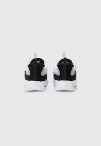 Hvite og svarte sneakers med en glatt tekstur, mesh-deler og en rosa detalj. Har en løkke for å dra i bak på hælen.