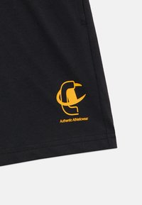 Μαύρο αθλητικό μπλουζάκι με κίτρινο λογότυπο και το κείμενο "Authentic Athleticwear" κοντά στο τελείωμα. Απαλό ύφασμα, κανονική εφαρμογή και κοντά μανίκια.