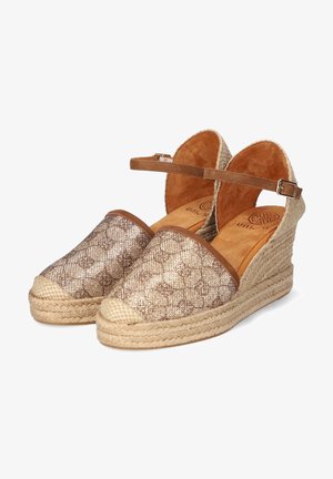 Sandales espadrilles compensées avec plateforme tissée beige, bout fermé à motif, et bride de cheville marron avec boucle.