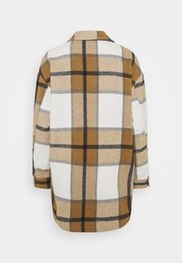 Camicia a maniche lunghe a quadri in beige, marrone e nero, con colletto a bottone e texture morbida, dal taglio rilassato e fessure laterali.