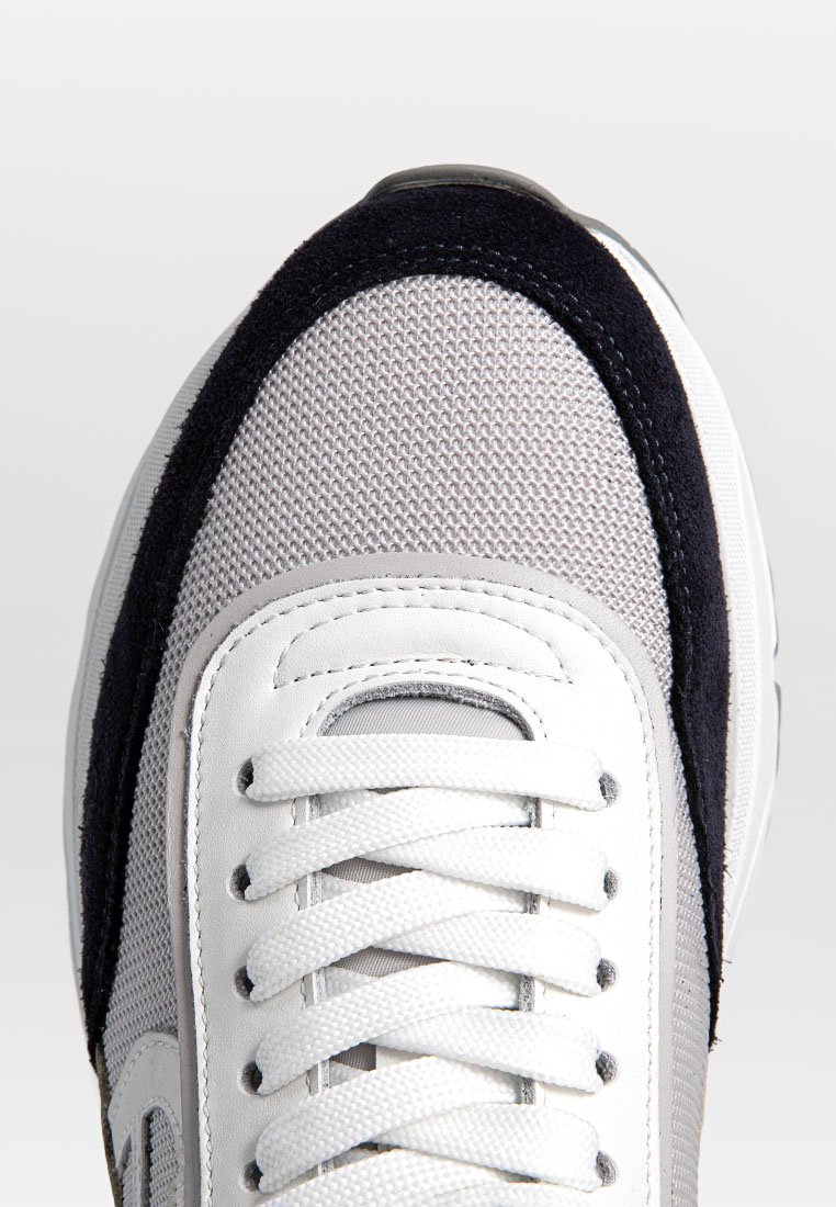 Weiße Sneaker mit einem Obermaterial aus Mesh, grauen Akzenten, Wildlederfersen und flachen weißen Schnürsenkeln. Runde Zehenpartie und gepolsterter Kragen für Komfort.