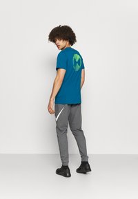 Nike Performance DRY TAPER - Pantalones deportivos - charcoal heather/white