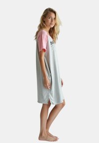 Camicia da notte grigia con maniche corte rosa e spacchi laterali, caratterizzata da una stampa di testo. Il materiale sembra morbido con una vestibilità comoda.