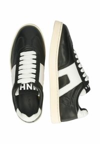 Svarta och vita sneakers med överdel i läder, vita snören, kontrasterande sidostrek och texturerad detalj på hälen.