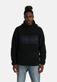 Felpa nera in pile con tasca a marsupio e un pannello nero opaco con il logo "SPYDER". Include un cappuccio con coulisse e un tessuto testurizzato.