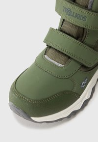 Zapatillas verdes para niños con dos correas de velcro, suela texturizada y una pequeña bandera noruega en el lateral.