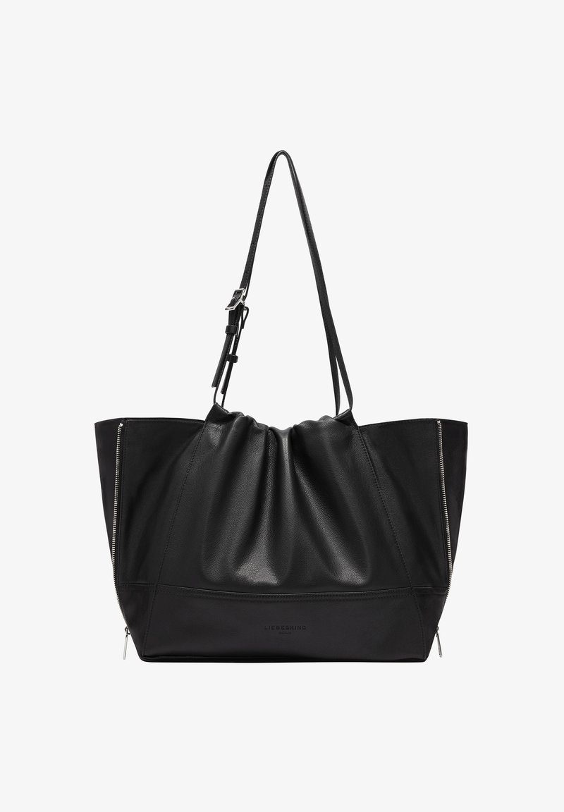 Sac tote en cuir noir avec un dessus froncé, équipé de poignées réglables et de fermetures éclair argentées de chaque côté. Texture lisse, design minimal.