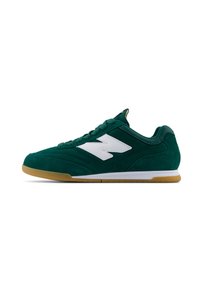 Zapatilla deportiva de gamuza verde con un logo blanco, cordones redondos y una suela de goma. Textura suave con un acolchado en el collar para mayor comodidad.