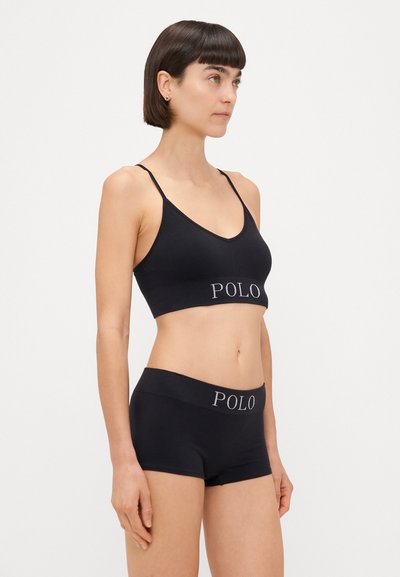 Čierny rebrovaný bralet s nastaviteľnými ramienkami a kontrastným logom "POLO" na páske, doplnený o čierne šortky typu boyshort s rovnakým logom.