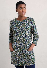Kwiatowa tunika w kolorach zielonym, niebieskim i białym, z rękawami o długości trzech ćwierć, okrągłym dekoltem i bocznymi kieszeniami, wykonana z teksturowanej, lekkiej tkaniny.