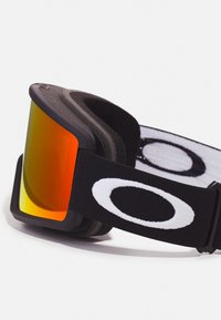 Svarta skidglasögon med en böjd, orange reflexlins och ett texturerat svart band med en stor vit logotyp. Mjuk vaddering för komfort.