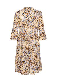 Robe à imprimé floral avec une base beige, présentant des taches marron, bleues et rouille. Elle a des manches trois quarts et une jupe à volants.