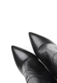 Stivaletti alla caviglia in pelle nera con punta appuntita, dalla texture liscia e design aderente, caratterizzati da una silhouette elegante e una forma affusolata.