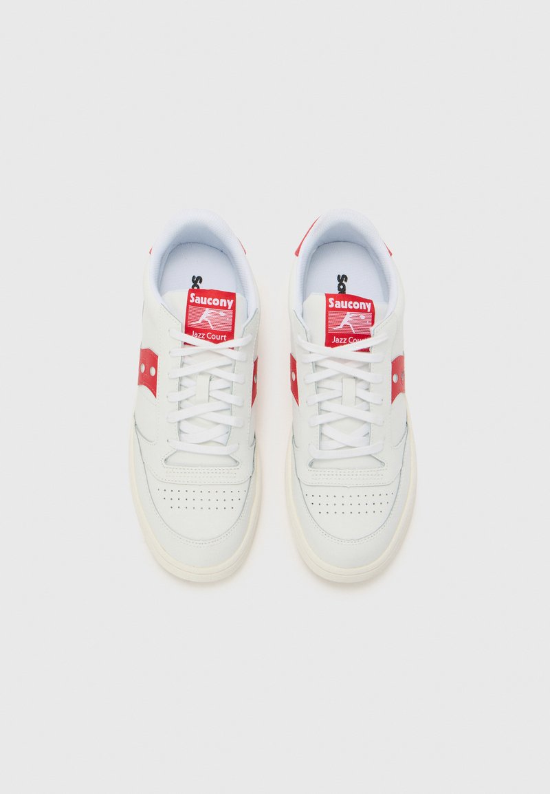 Sneakers bianchi con dettagli e loghi rossi, dotati di una tomaia in pelle liscia, perforazioni sulla punta e suola in gomma.