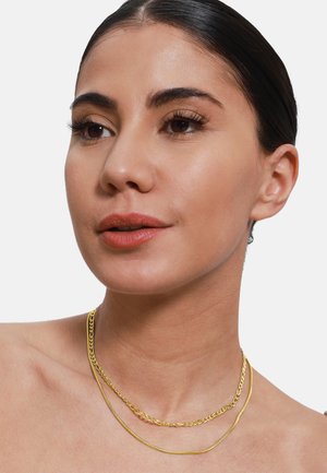 Collier superposé en ton doré avec une chaîne plate et une délicate chaîne serpent. Texture lisse avec une finition polie.
