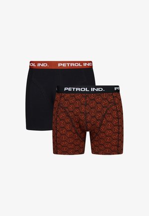 Zwei Paare Herrenboxershorts. Ein Paar ist schwarz mit einem roten "PETROL IND." Bund; das andere hat ein oranges geometrisches Muster mit einem schwarzen Bund.