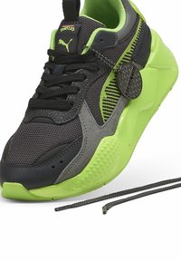 Baskets montantes en maille noire et cuir synthétique, avec des accents néon verts, des panneaux gris texturés et une étiquette ronde attachée aux lacets.