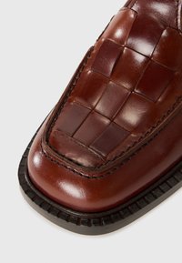 Braunes Leder-Schuh mit gewebtem Oberdesign, abgerundetem Zeh und strukturierten Akzenten. Verfügt über eine schwarze gerippte Sohle und feine Nähdetails.
