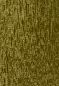 Tekstureret grønt materiale med en ru, prægede overflademønster, der indeholder lodrette og vandrette linjer for at give dybde og interesse.