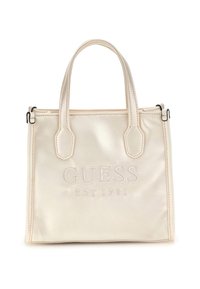 Borsa a tracolla color crema con due manici e "GUESS EST 1981" ricamato sul davanti, sfondo semplice.