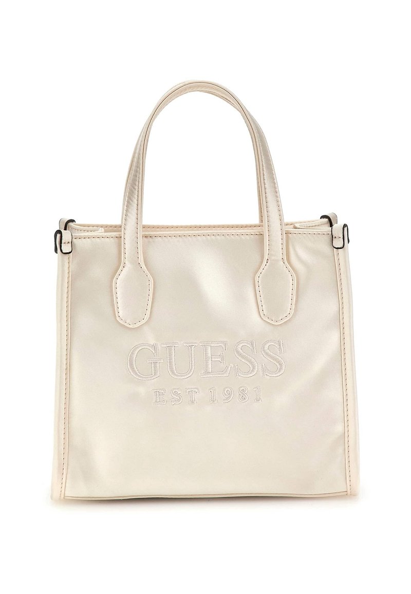 Borsa a tracolla color crema con due manici e "GUESS EST 1981" ricamato sul davanti, sfondo semplice.