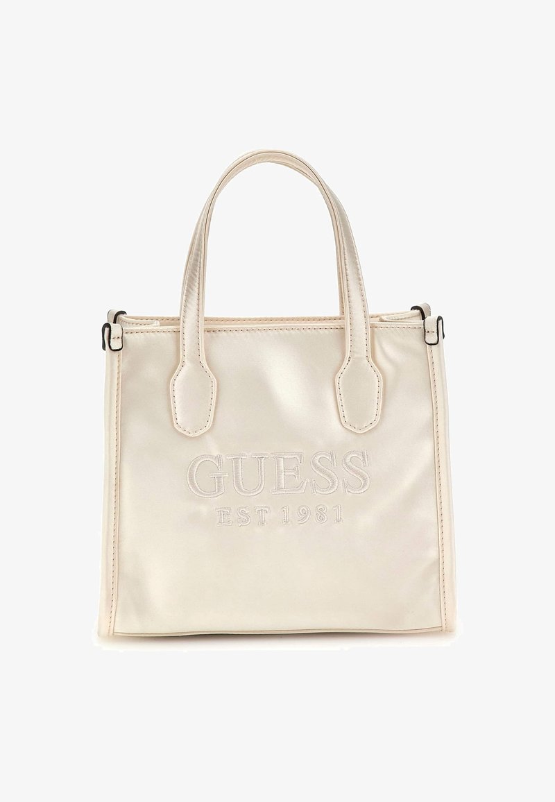 Borsa a tracolla color crema con due manici e "GUESS EST 1981" ricamato sul davanti, sfondo semplice.