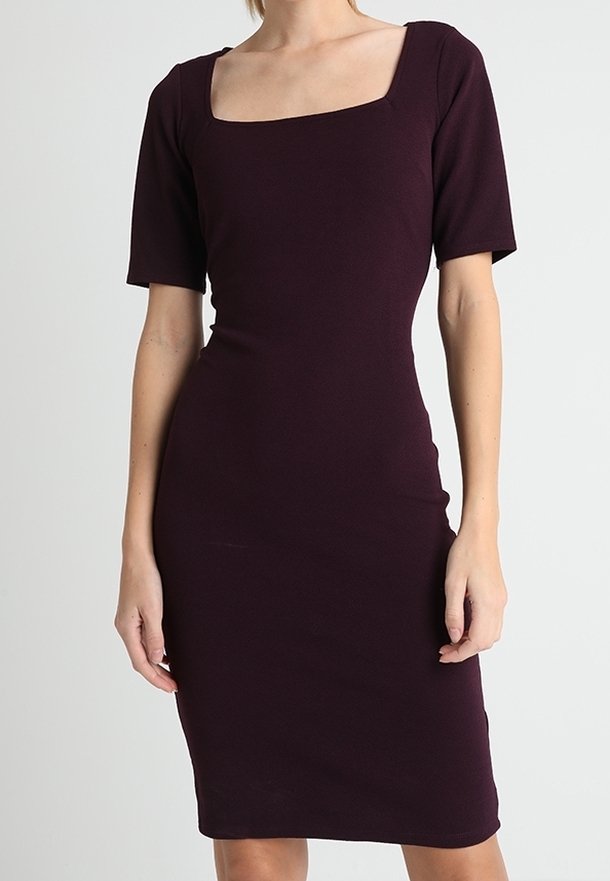 Tight passande knälång klänning i djupt vinröd med korta ärmar och fyrkantig halsringning. Tillverkad av stretchmaterial med en mjuk textur.