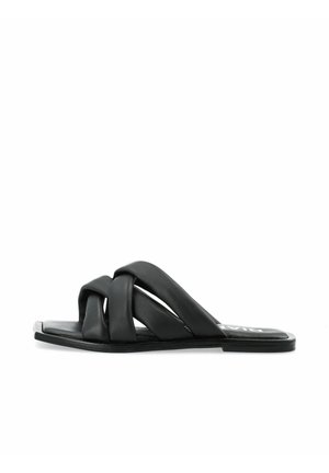 Sandalo scivoloso in pelle nera con fascette incrociate, suola piatta e design minimalista. Texture liscia con una leggera lucentezza.