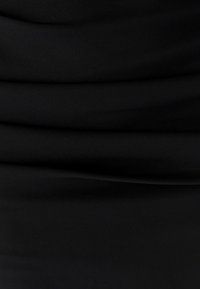 Zwarte stof met een geplooide textuur, een glad oppervlak en zonder zichtbare patronen of accenten. Het materiaal lijkt lichtgewicht en flexibel.