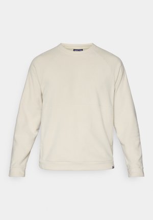 Lys beige sweatshirt med rund halsudskæring, raglanærmer og tekstureret stof. Kantene er let cropped med et logo på siden.