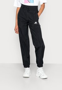 Zwarte lichtgewicht joggers met een gekorrelde afwerking, elastische tailleband, trekkoord en zijzakken. Witte logo-accent op de dij.