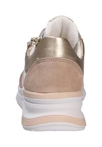 Basket beige avec un talon en métal doré et une texture en daim. Présente une semelle intermédiaire blanche et un détail de fermeture éclair sur le côté.